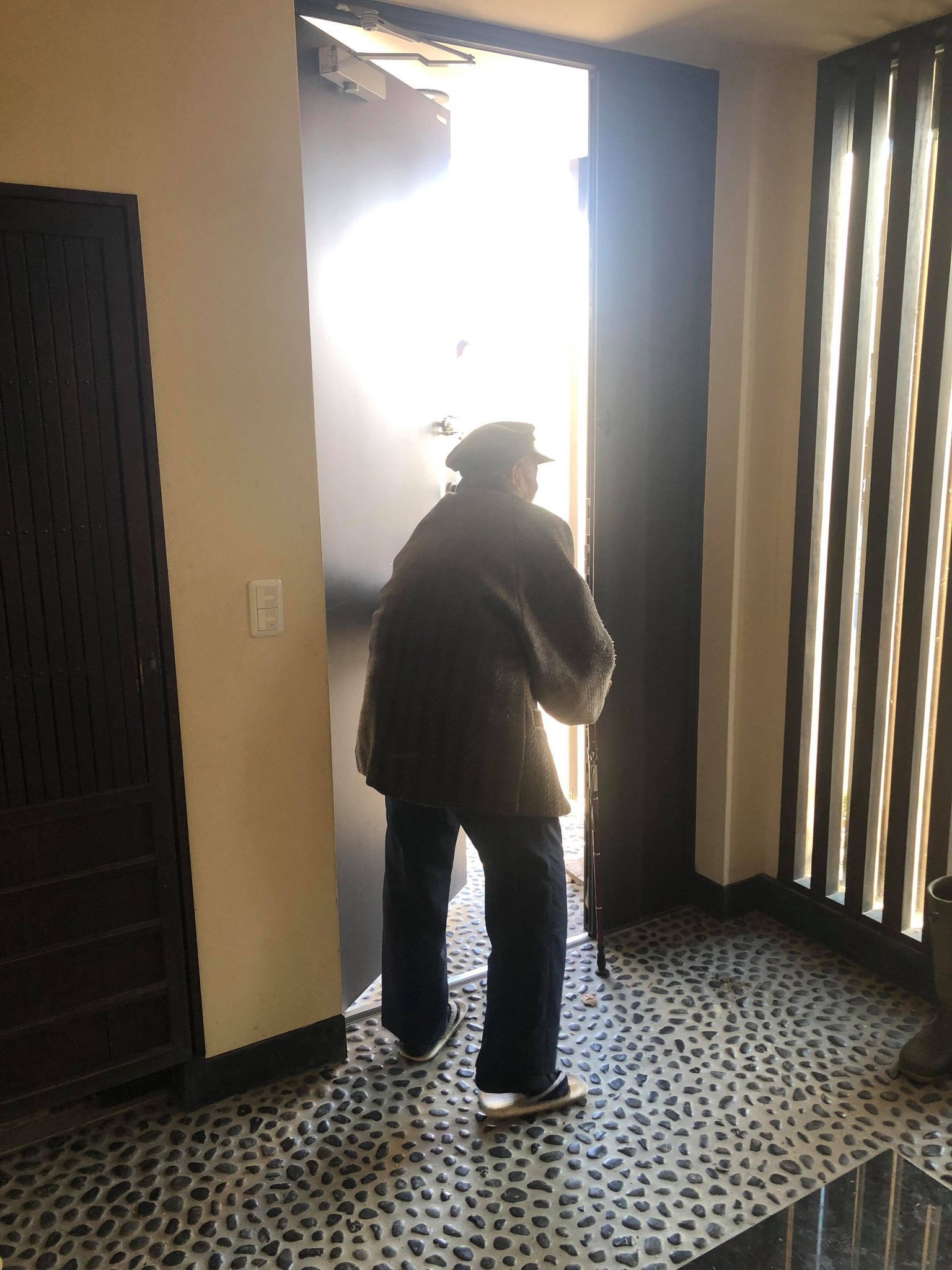 玄関から出ていく高齢者