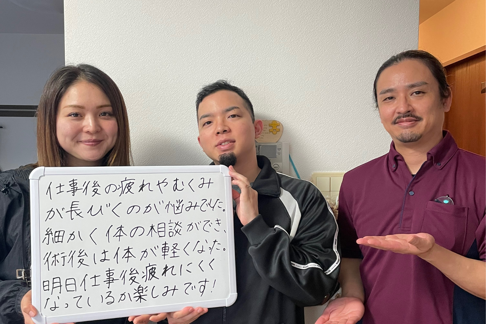 施術を受けた体が軽くなったと喜ぶご夫婦と出張整体パピル代表の下里が一緒に写っている写真