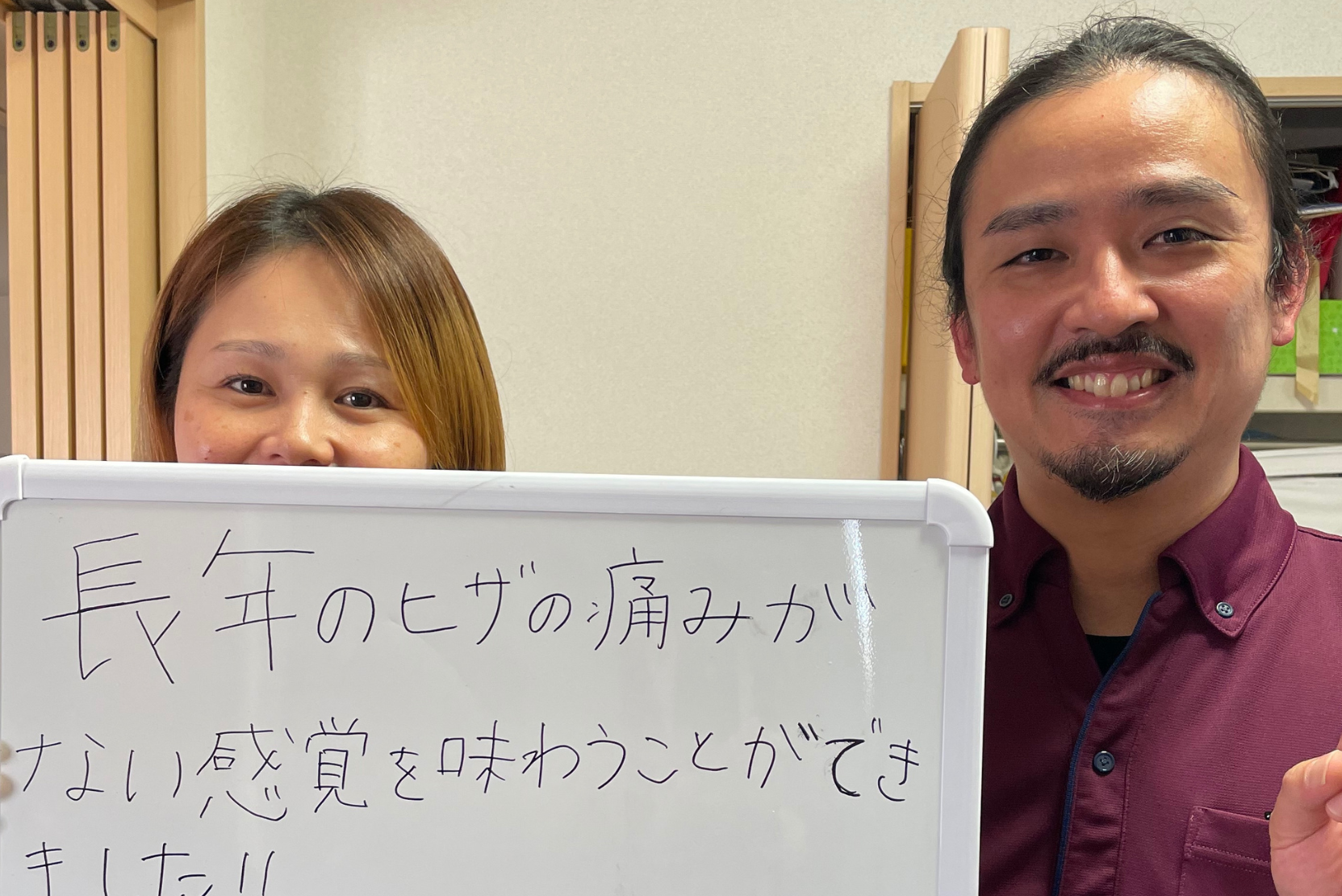 施術を受けて膝と腰の痛みが改善したと笑顔の女性が出張整体パピル代表の下里と一緒に写っている写真
