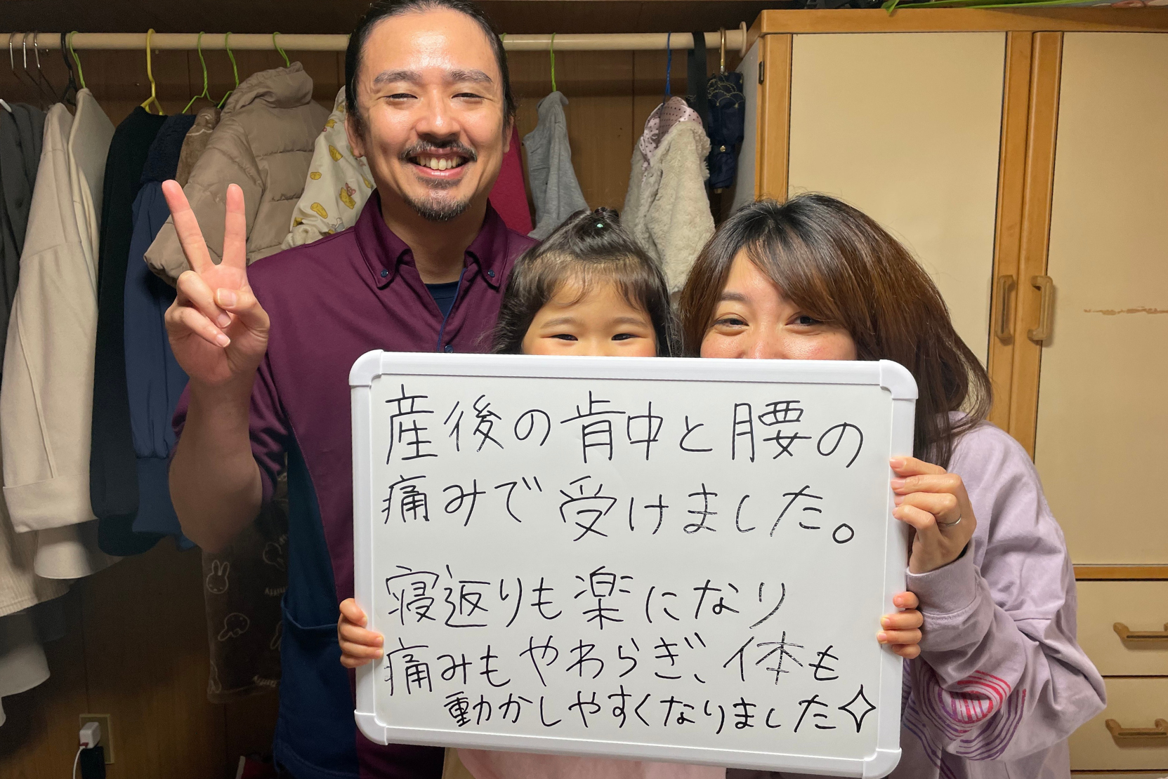 施術を受けた女性が、産前産後の腰痛と腰の痛みが改善したと笑顔で娘と出張整体パピル代表の下里と一緒に写っている写真