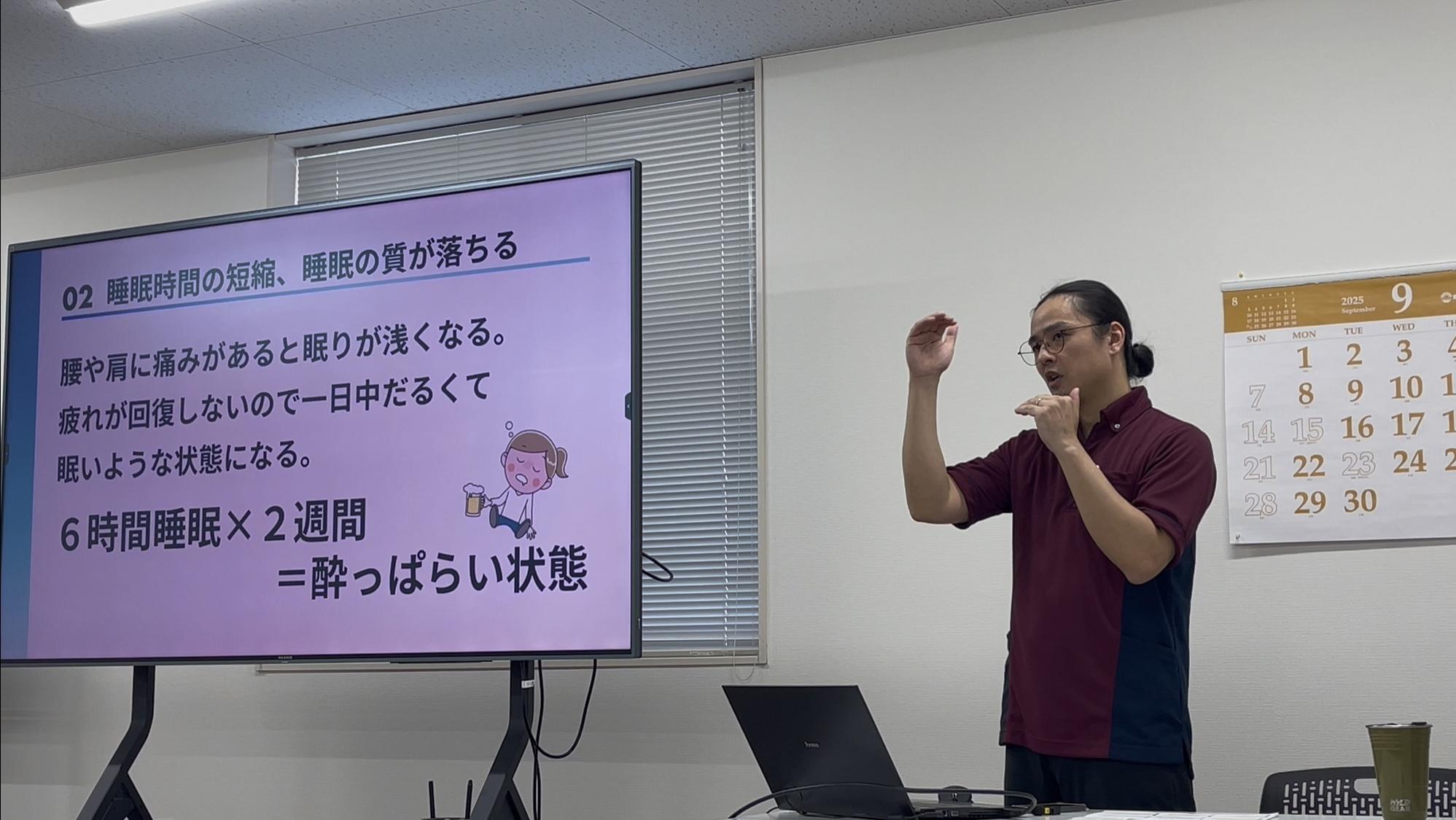 セミナーで講師を務める下里が参加者の前にあるモニターの横で話している写真