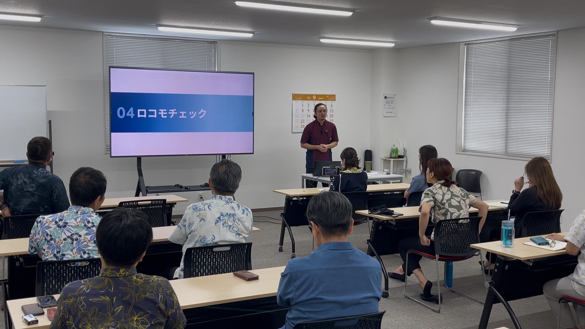 腰痛と肩こりセミナーで講師の下里が話している内容を参加者が興味深そうに聞いている風景