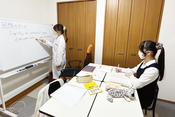 机を挟んで個別指導をしている様子