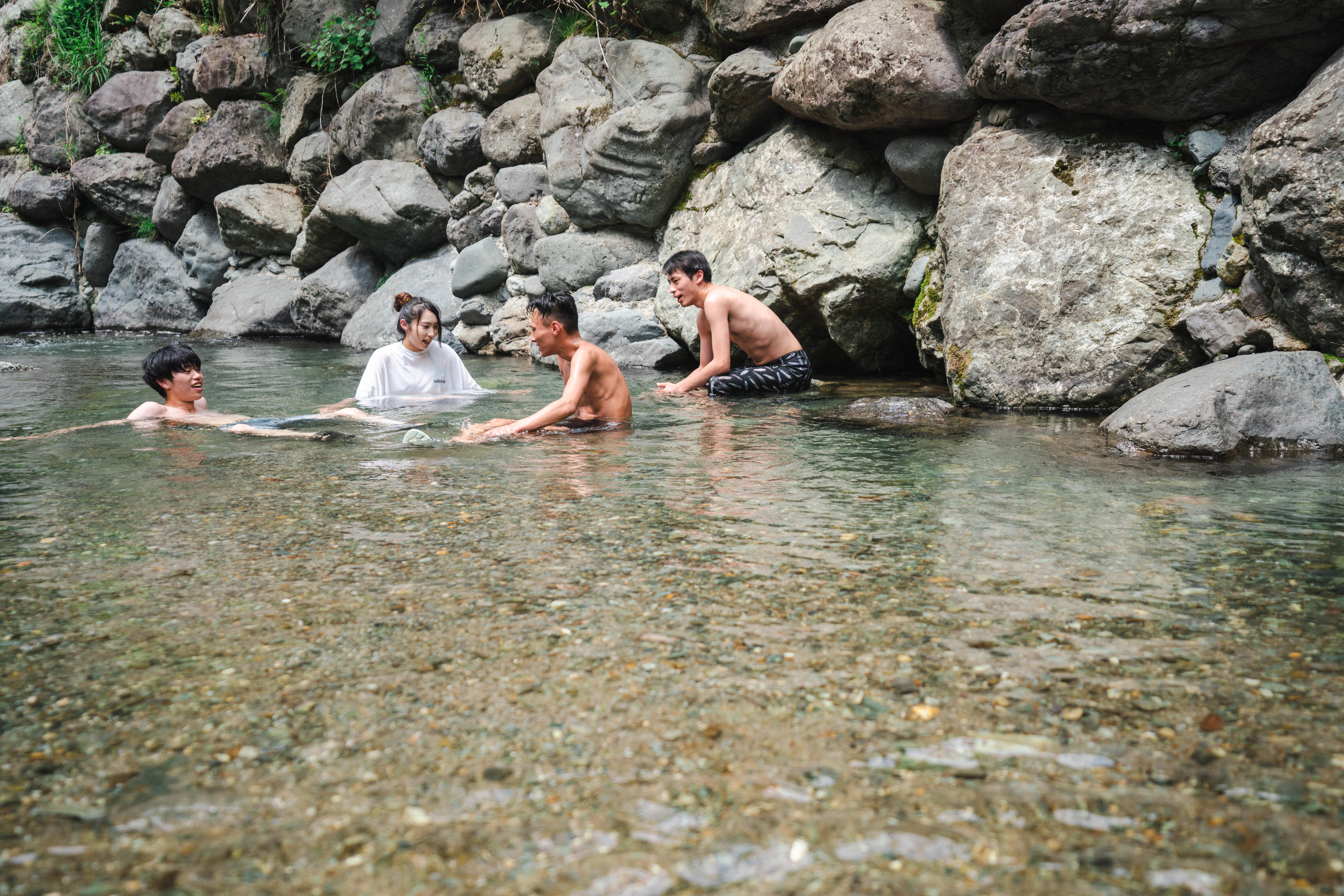 テントサウナの後川に入って水風呂している様子