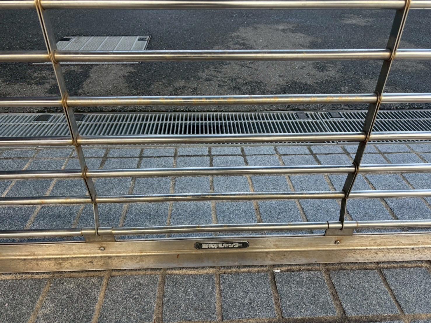 施工前の格子状のシャッター。下部を中心に茶色い汚れが見られる