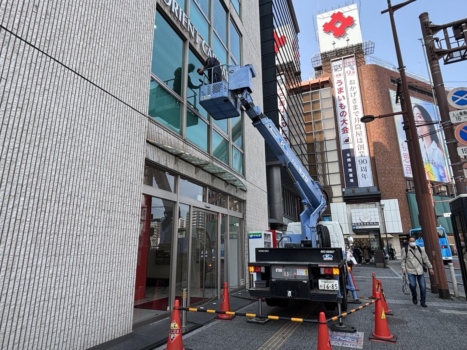 高所作業車を使用したビル外窓ガラス清掃の作業風景