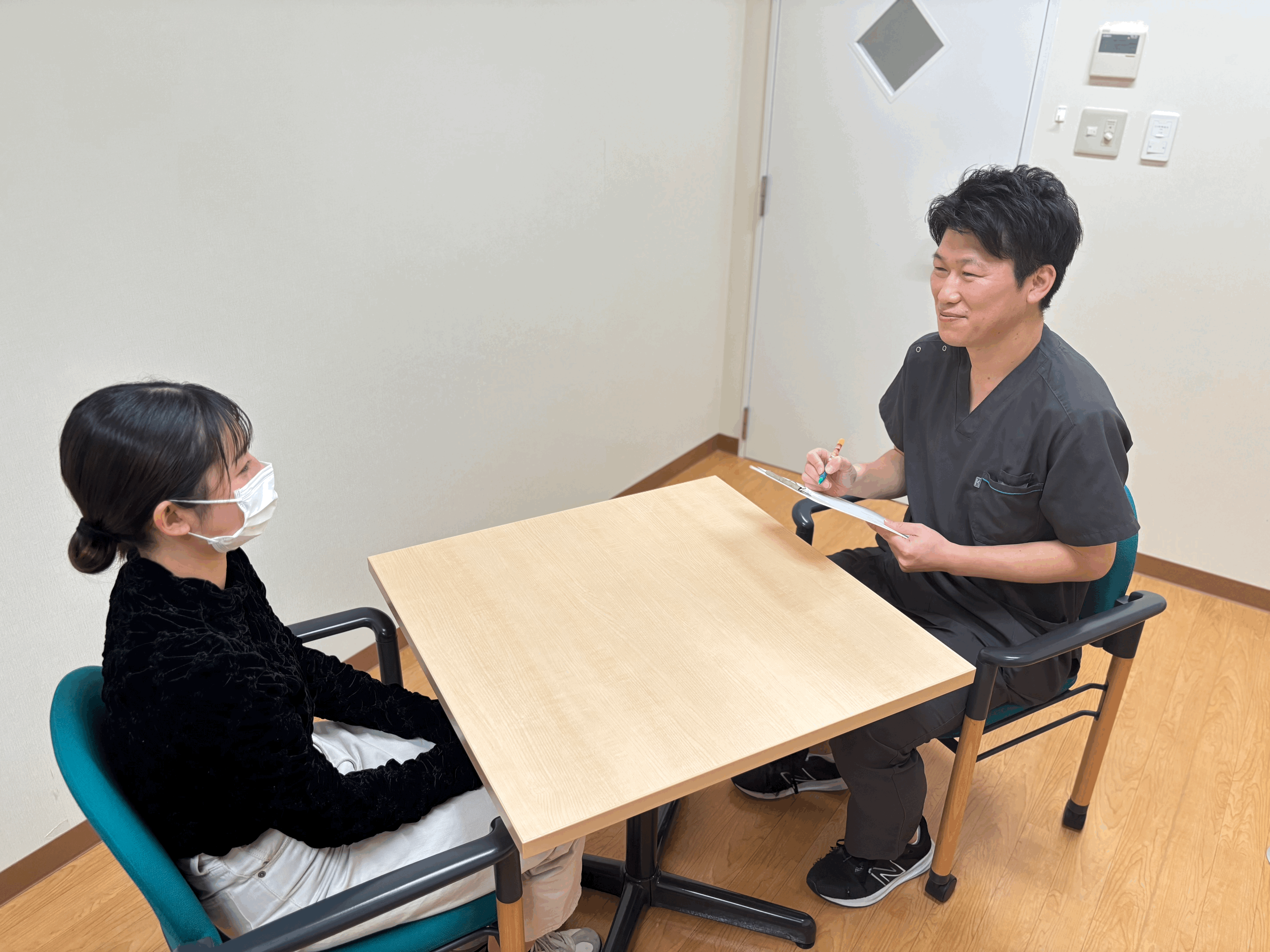 腰痛整体オーダーケアサロンVoiceでクライアントにカウンセリングをしている風景。