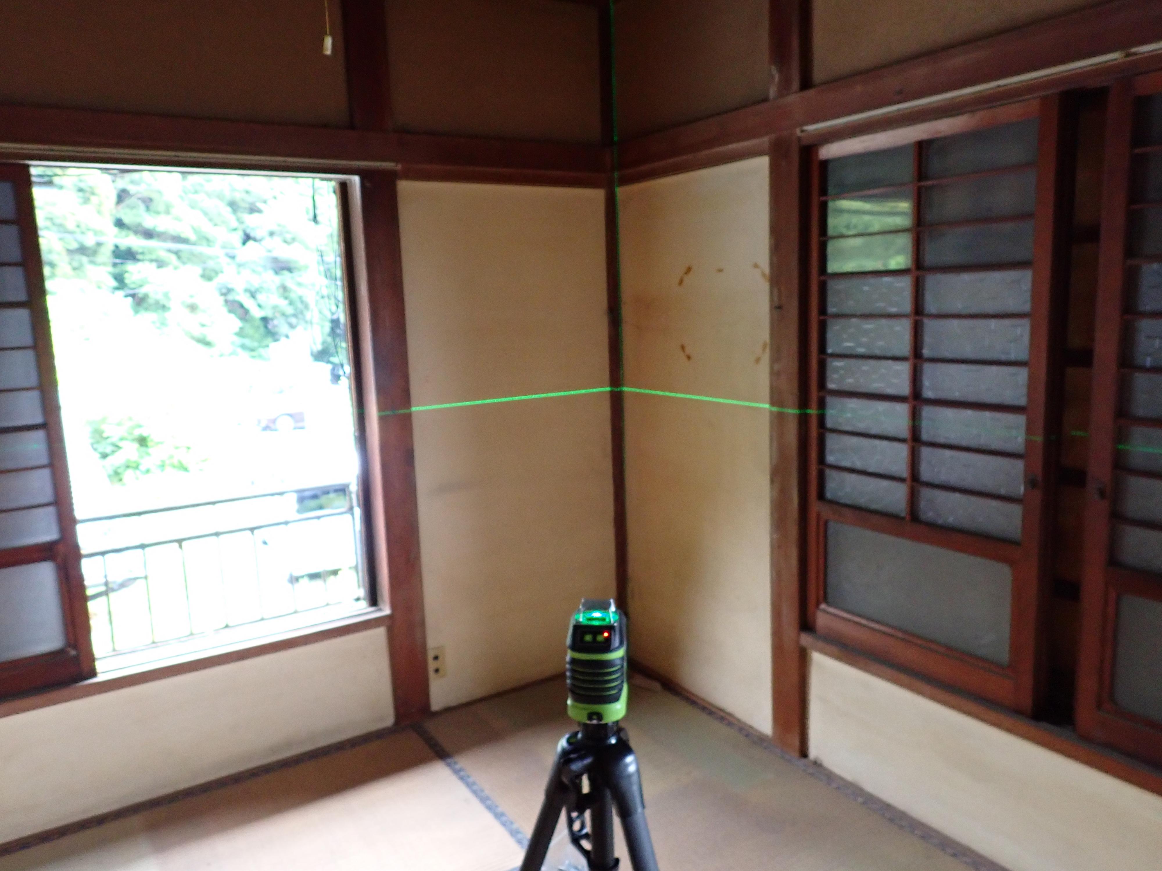 レーザー水平器で床の傾斜を測定している写真