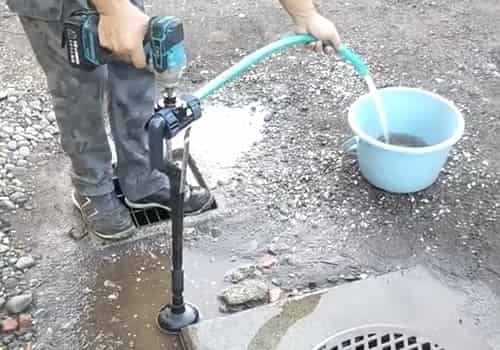グラウンドの水たまりをドリルポンプで水抜き｜特許出願済み