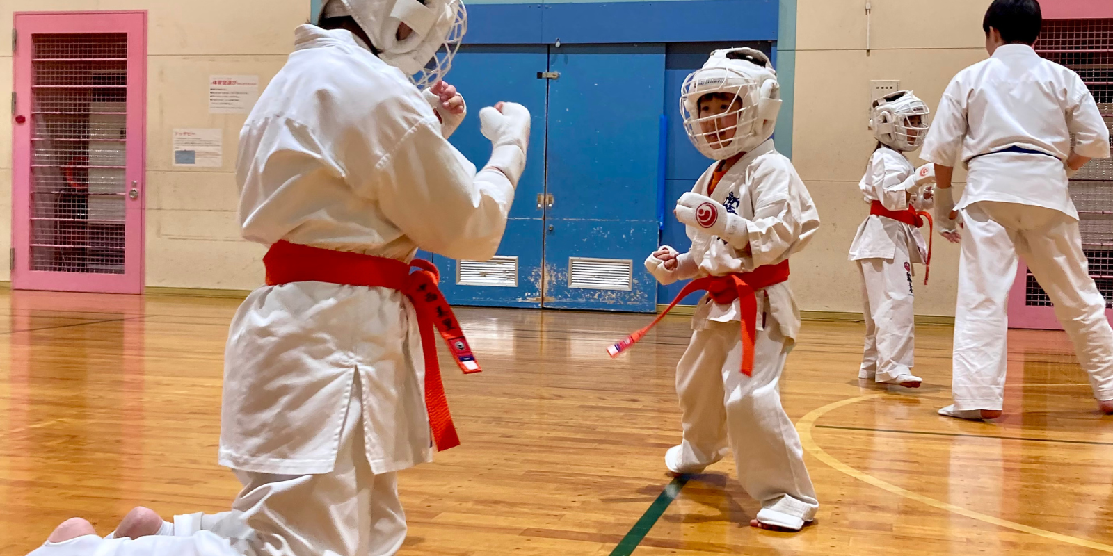 札幌円山の空手道場で、防具を着用した親子組み手を通して安全に稽古する様子
