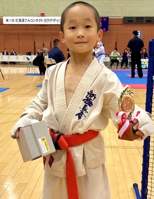 札幌市の小学生空手大会で優勝し、トロフィーを持つ小学6年生男子軽量級の選手