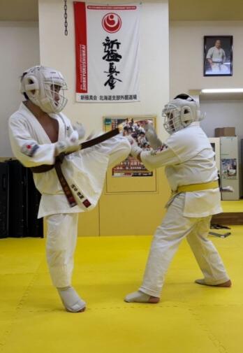 外舘道場強化クラスの組手稽古。中学生選手が鋭い蹴りを放ち、高度な技術とスピードを競い合う本格的な練習シーン。