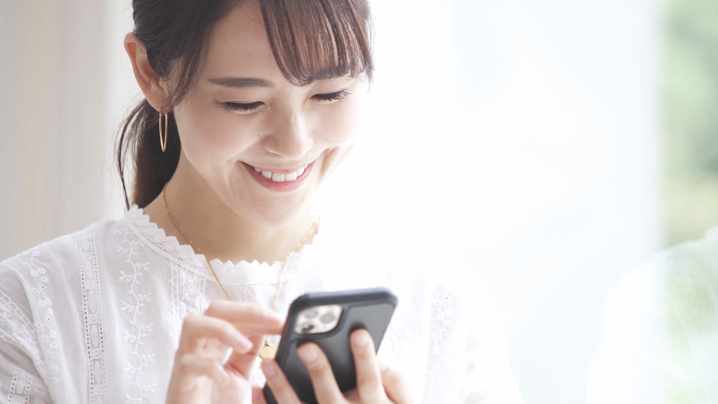 スマホで動画を見ている女性