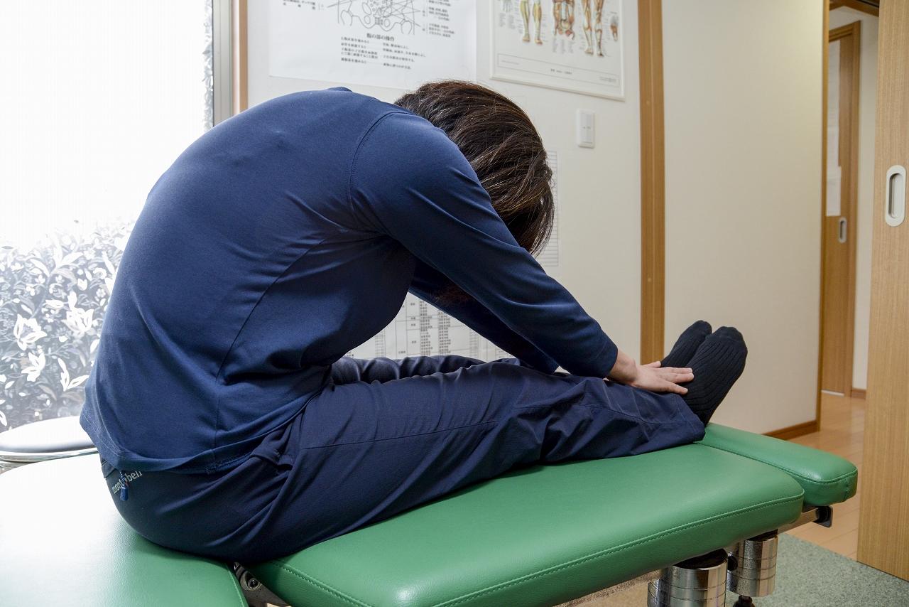 【腰痛の動作痛の検査】長座で前屈して痛みを確認している