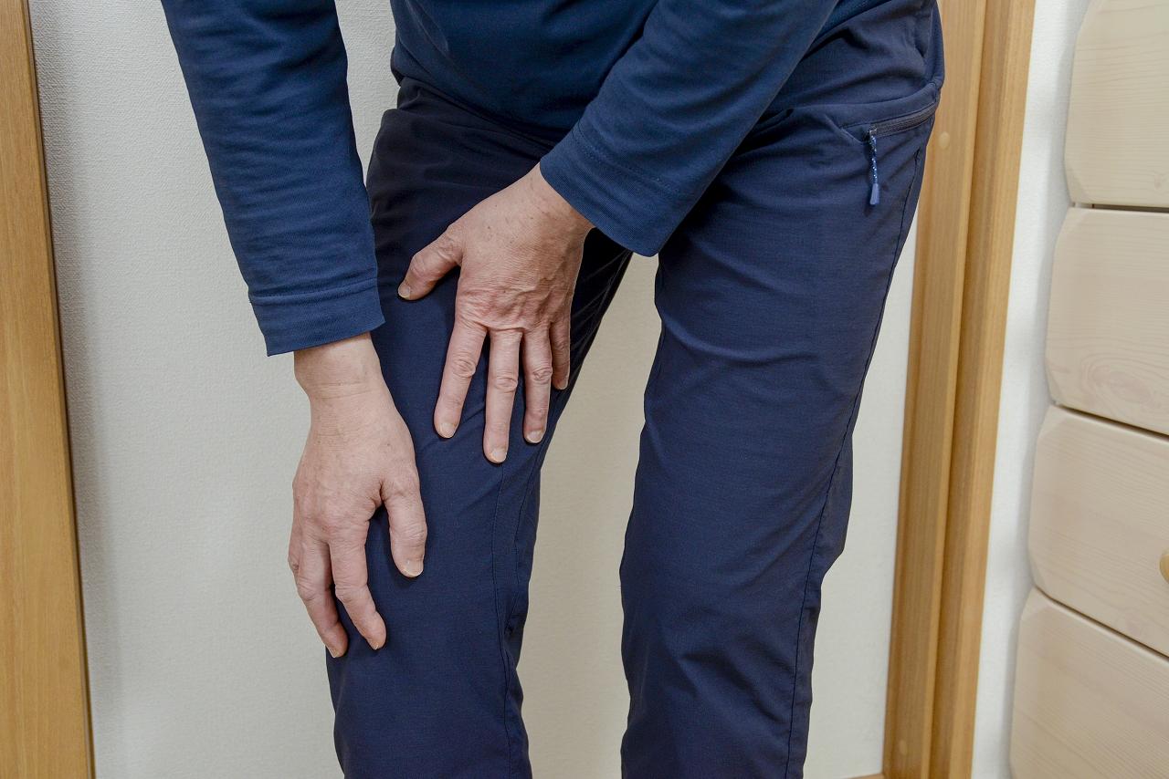 【ひざ痛】膝を押さえて痛いところを示している