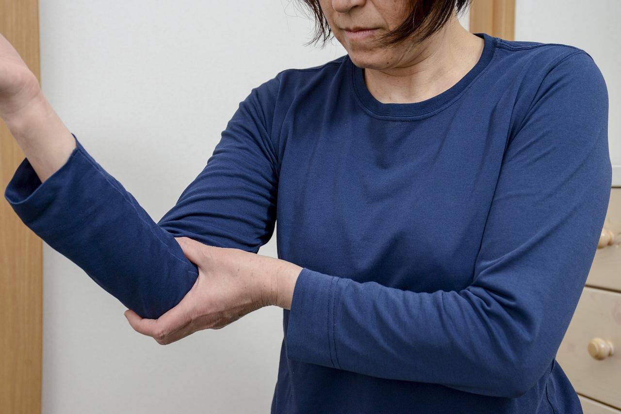 【肘痛】肘を曲げて痛い個所を押さえている
