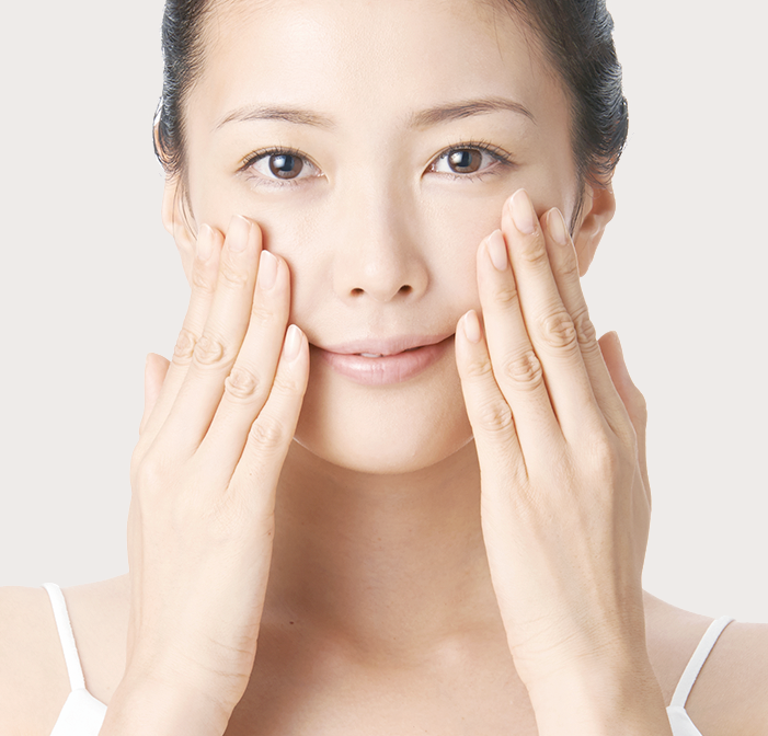 女性がなめらかな肌を両手で触っている写真