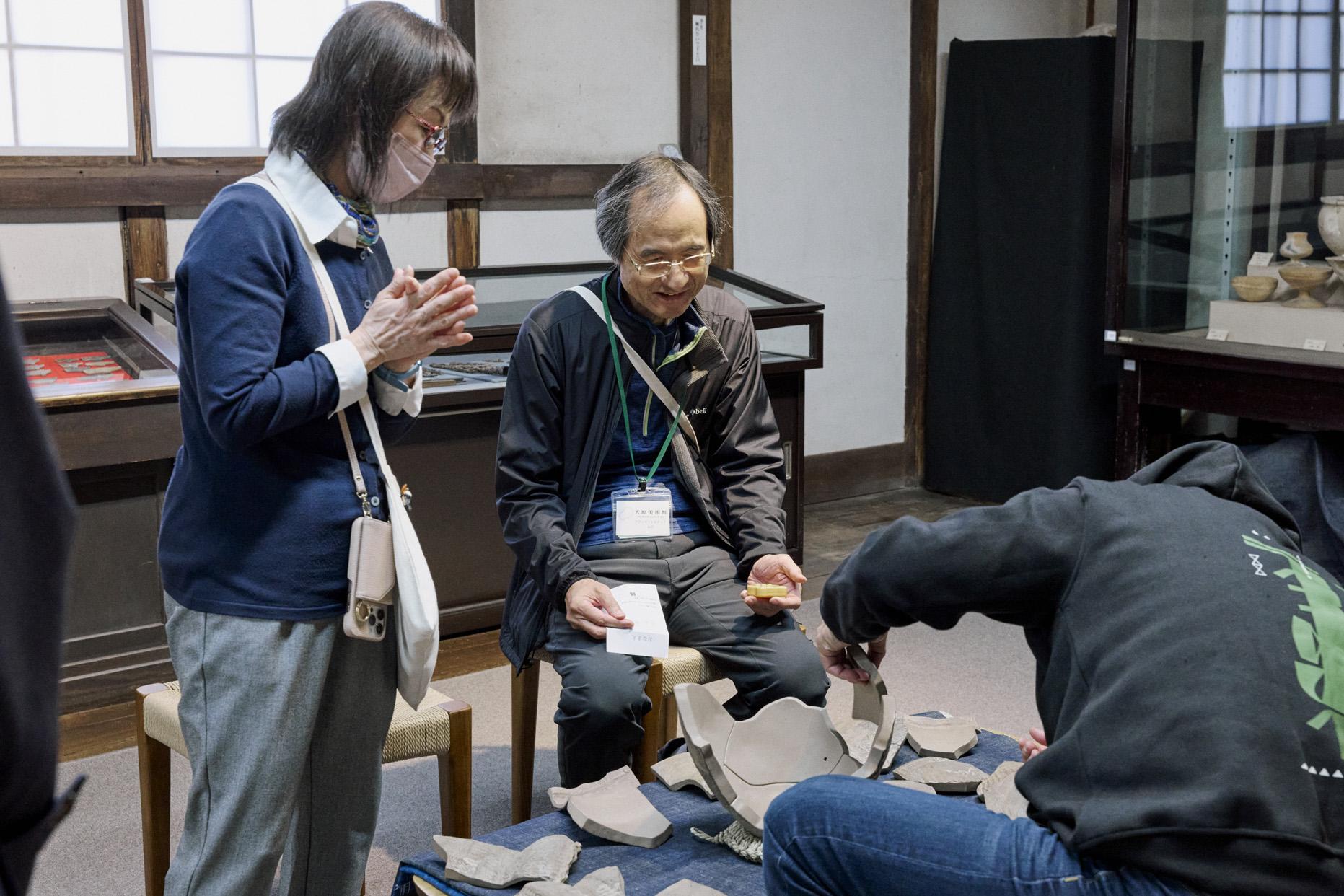 土器パズル参加者を見守るスタッフ