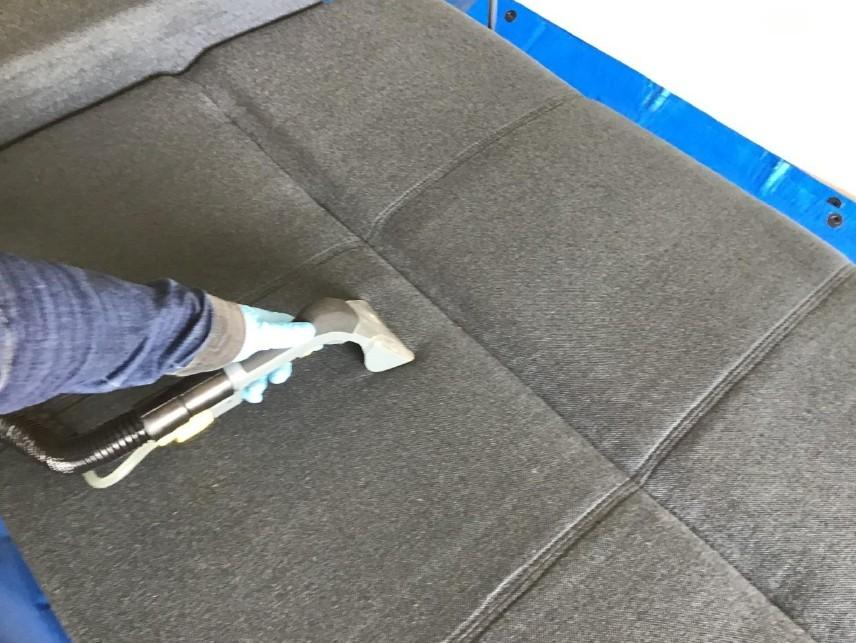 専用リンサーで布製ソファーを洗浄している様子