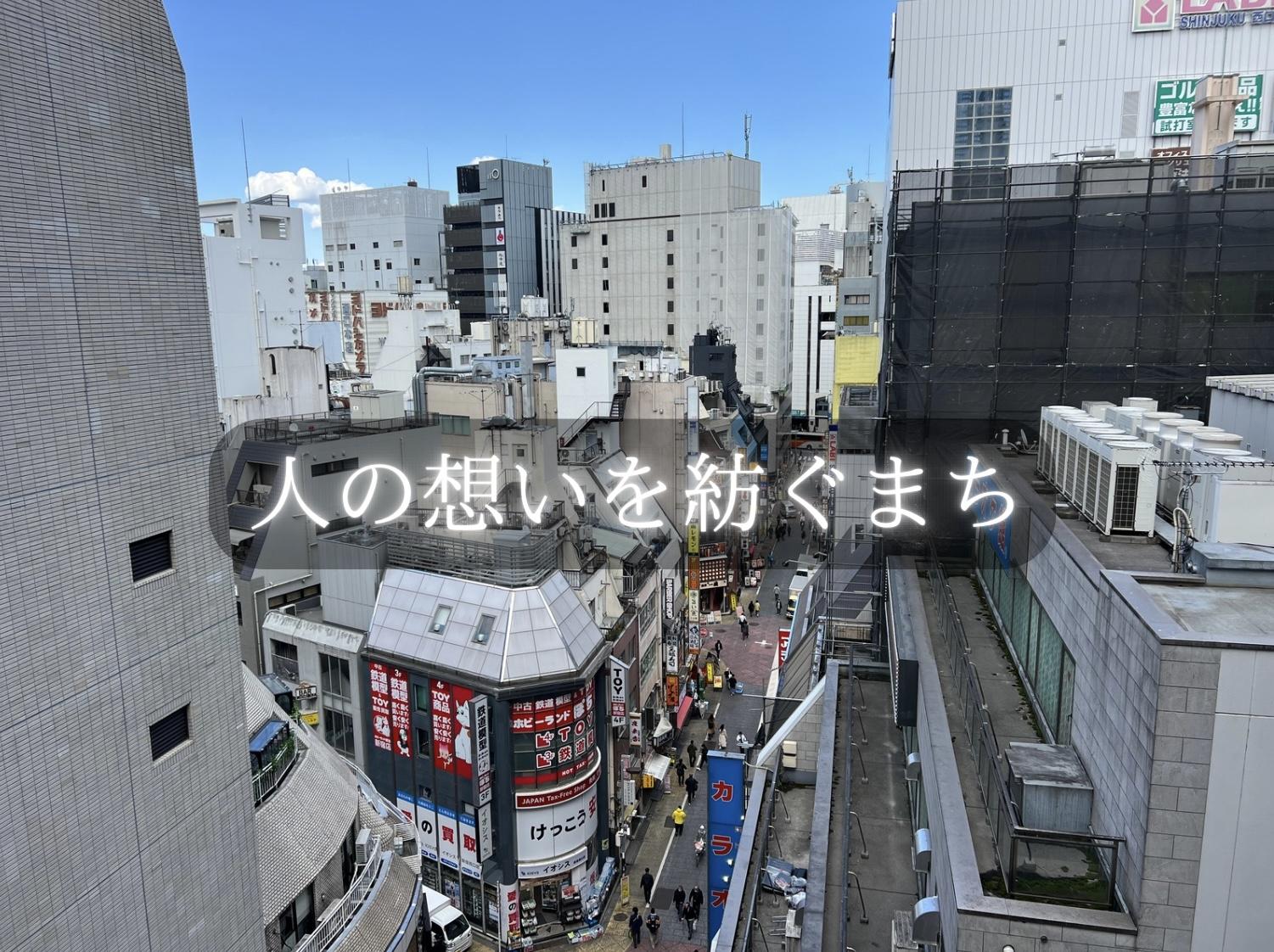 新宿駅周辺のビル群とにぎわう通りを上空から見下ろした風景写真