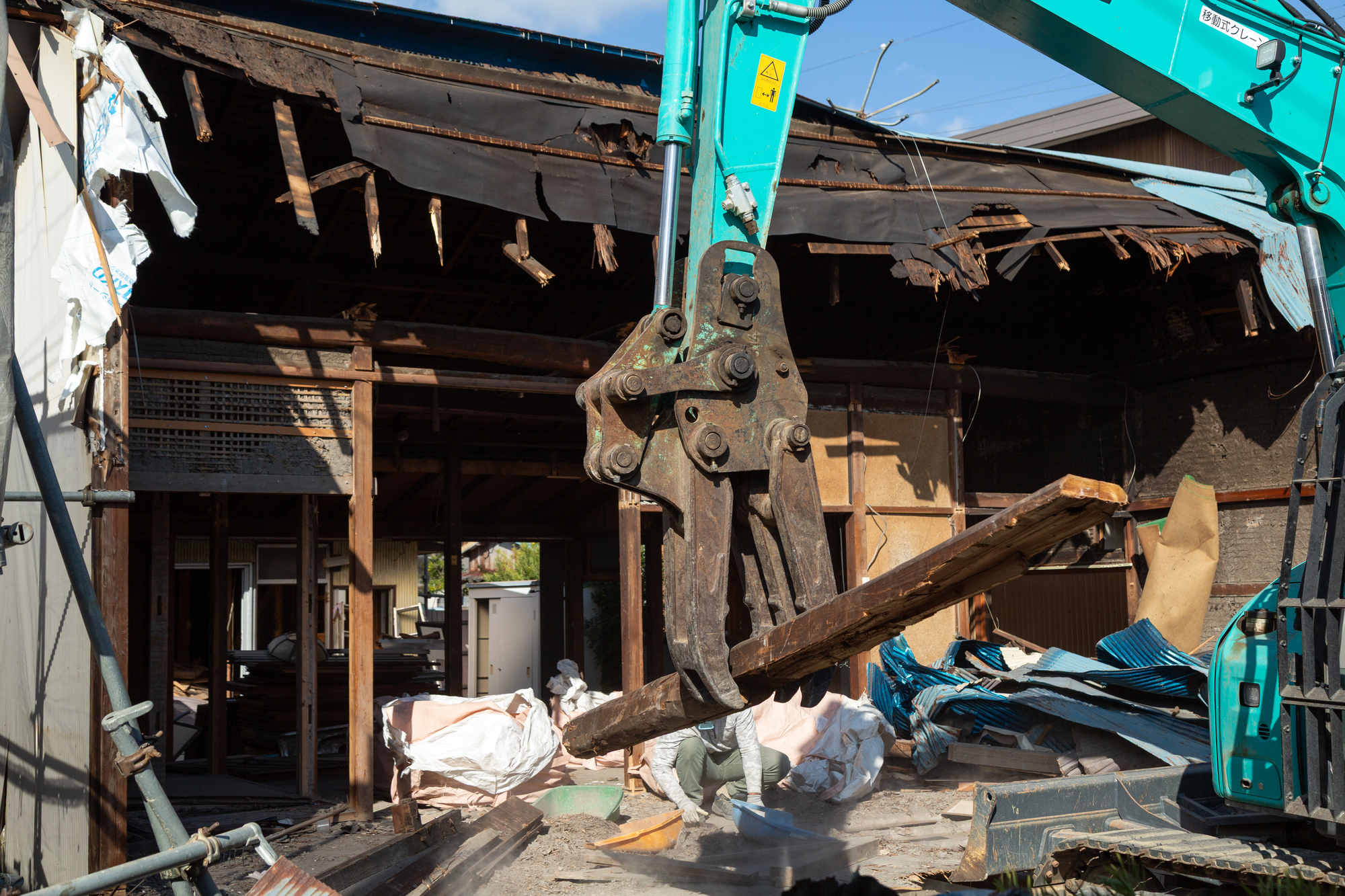 ユンボで解体材を掴んでいる写真