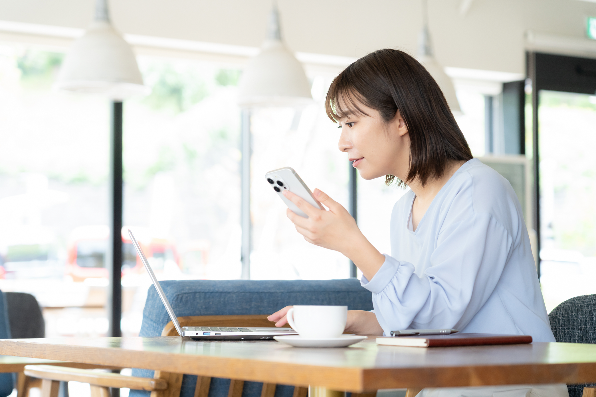 女性がPCとスマホで仕事をしている様子の写真