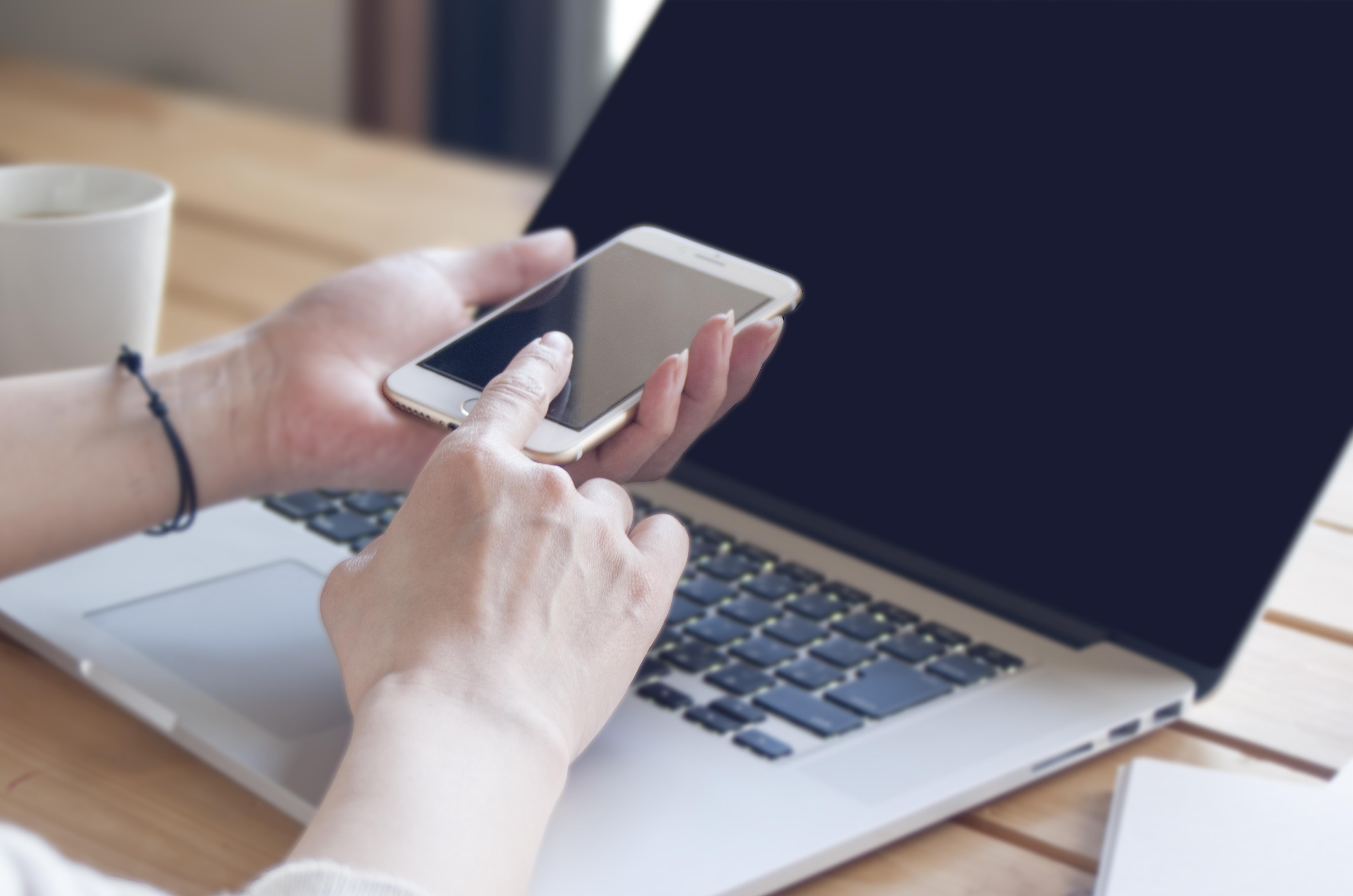 PCを見ながらスマホを操作している写真