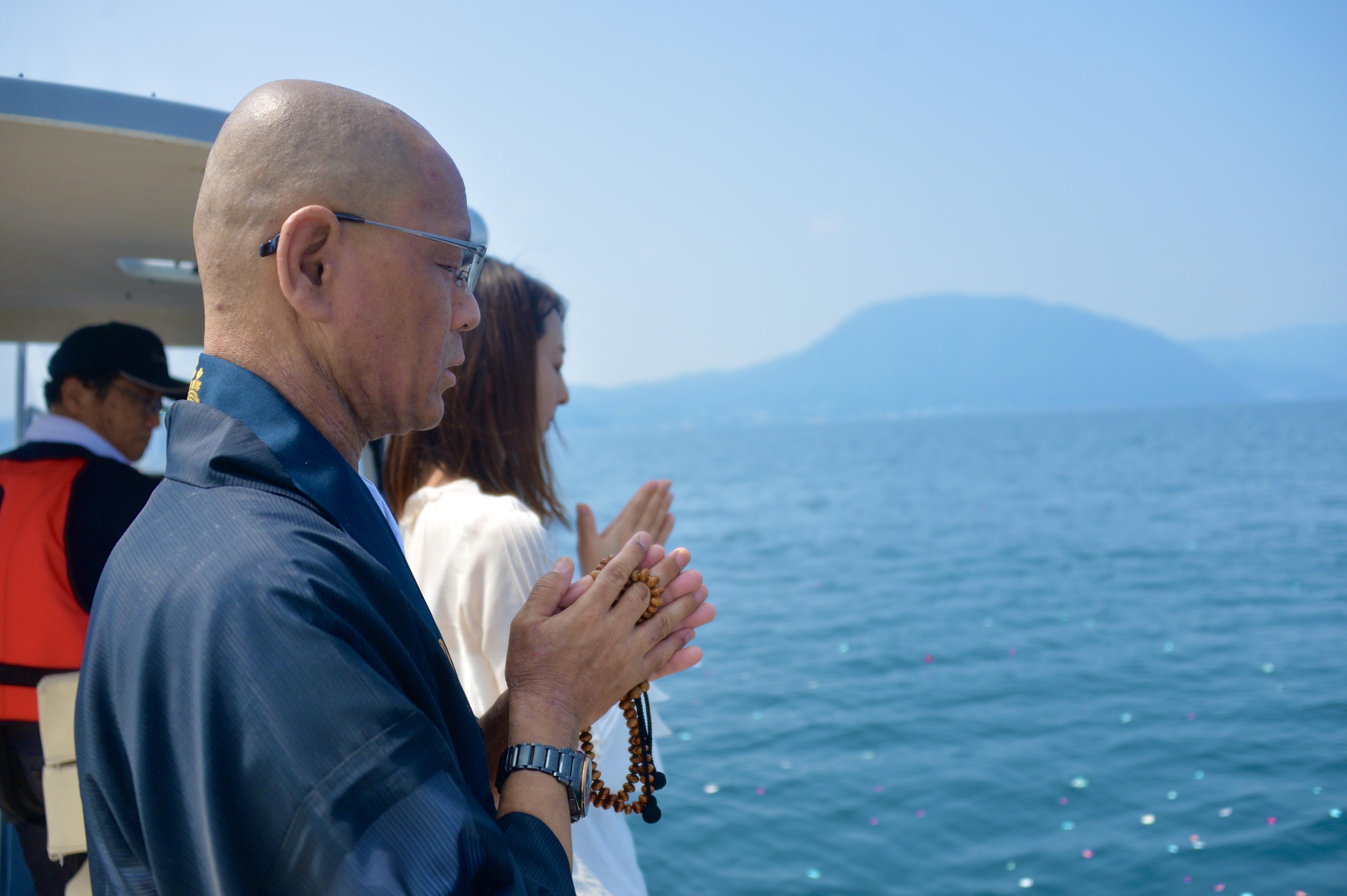 大分で海洋散骨永代供養祭で僧侶と女性がお経を読み上げる写真