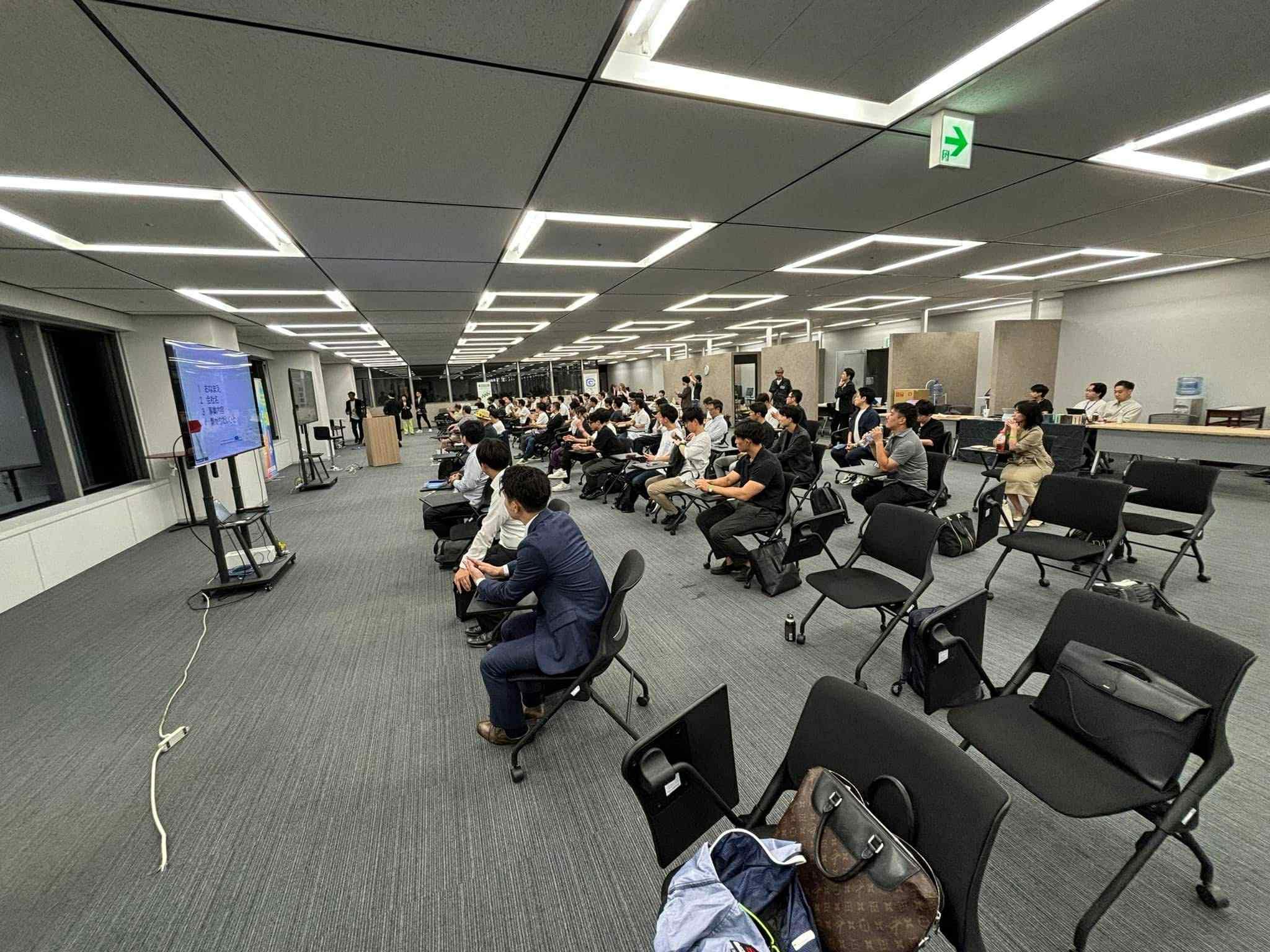 ビジネス交流会で熱心にモニターを視聴する様子