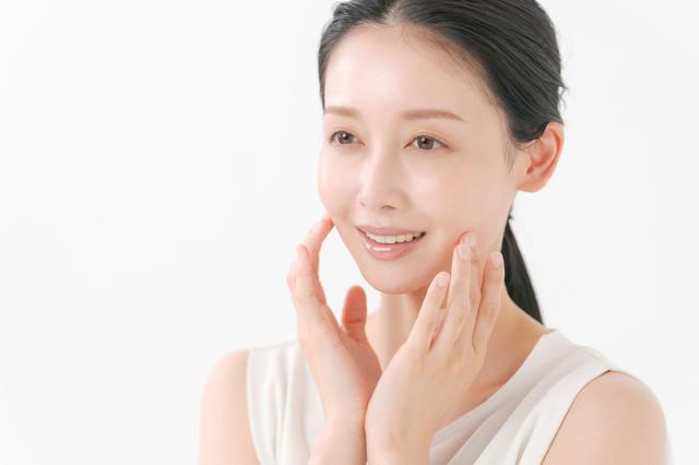 引き締められたほほを確認する女性