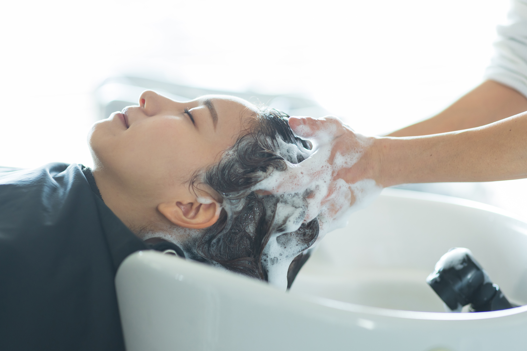 シャンプーで皮脂汚れを落としている女性