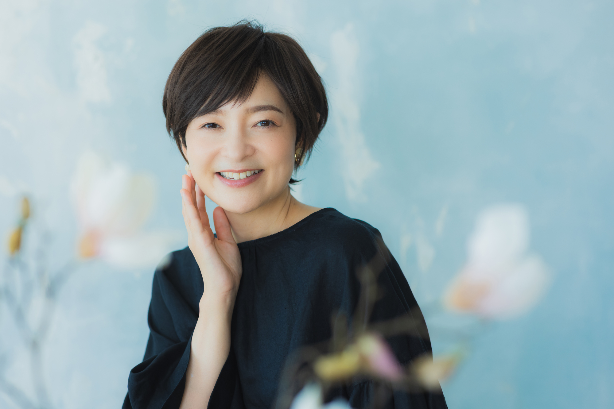 ウィッグをつけて微笑む黒いカットソーの女性