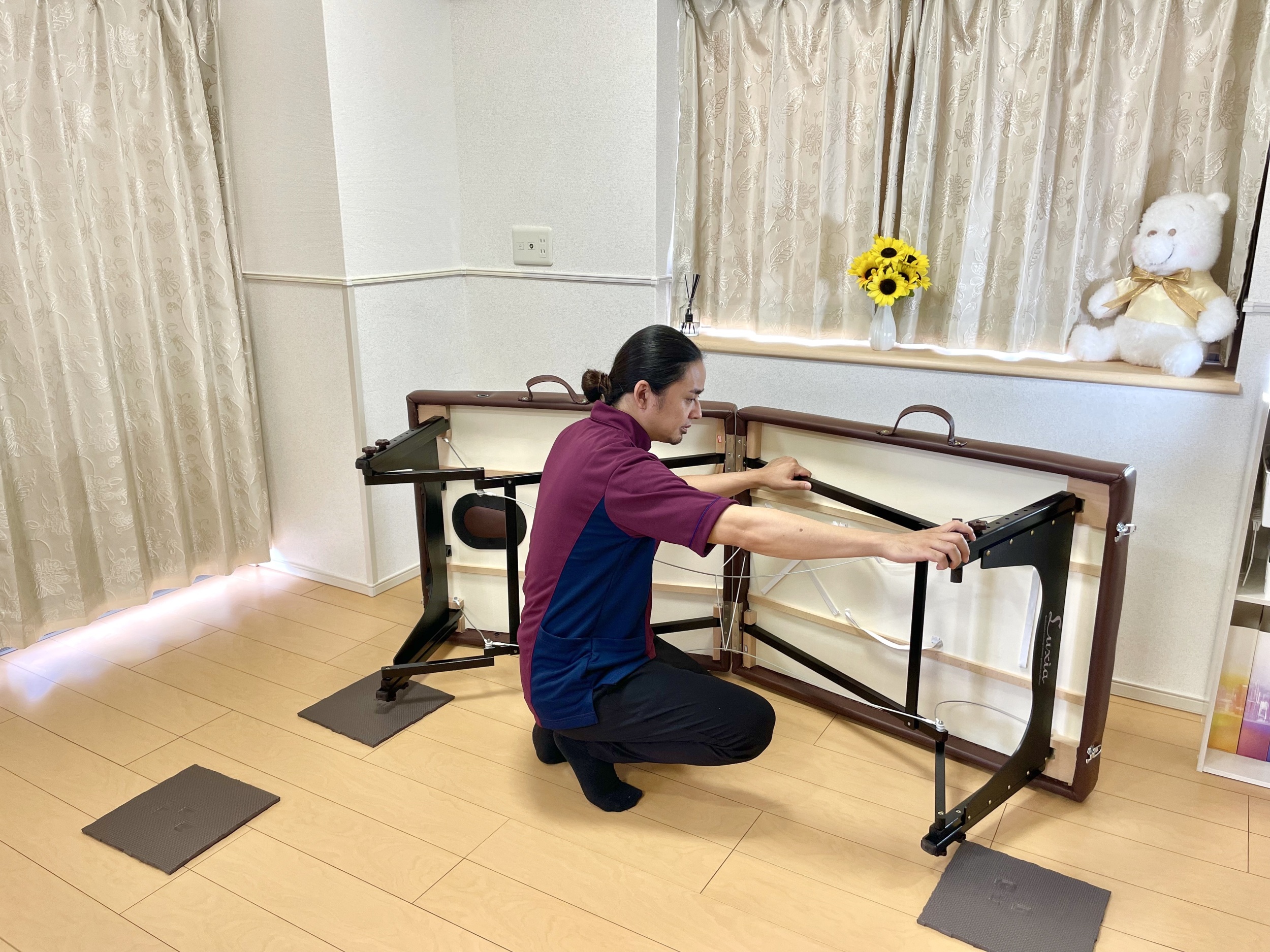 出張整体パピル代表の下里が施術ベッドを設置している写真