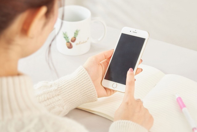 スマホを見る女性の画像