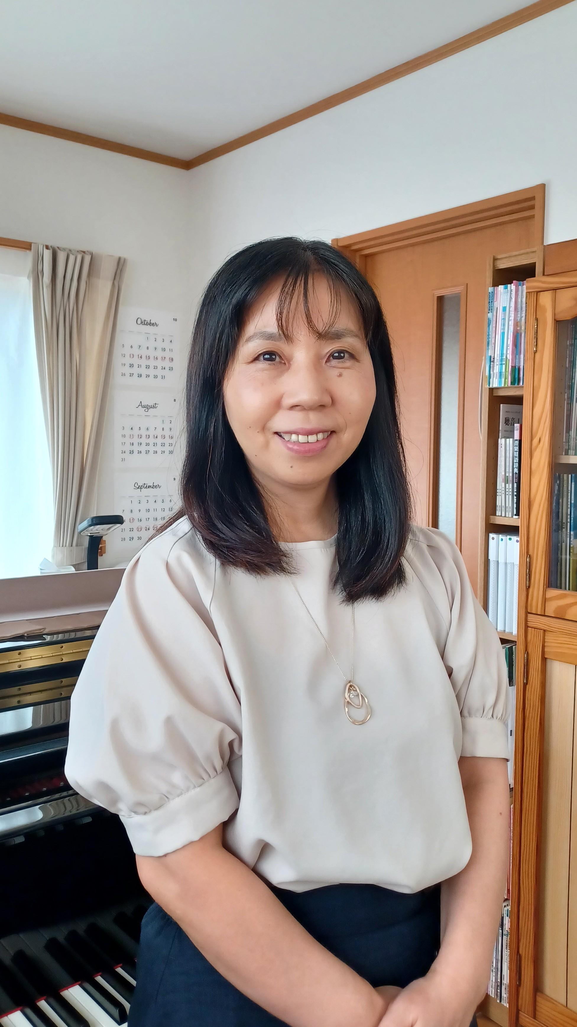 ピアノの前に立つ女性