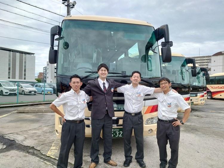 営業所に並ぶ車両と運転士たち