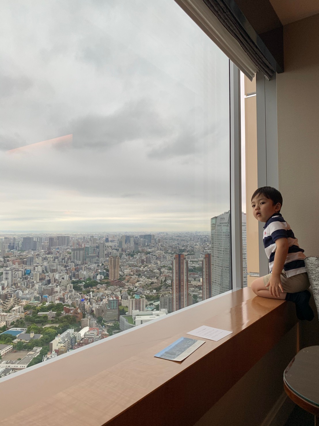 男の子がホテルの窓から外を眺めている