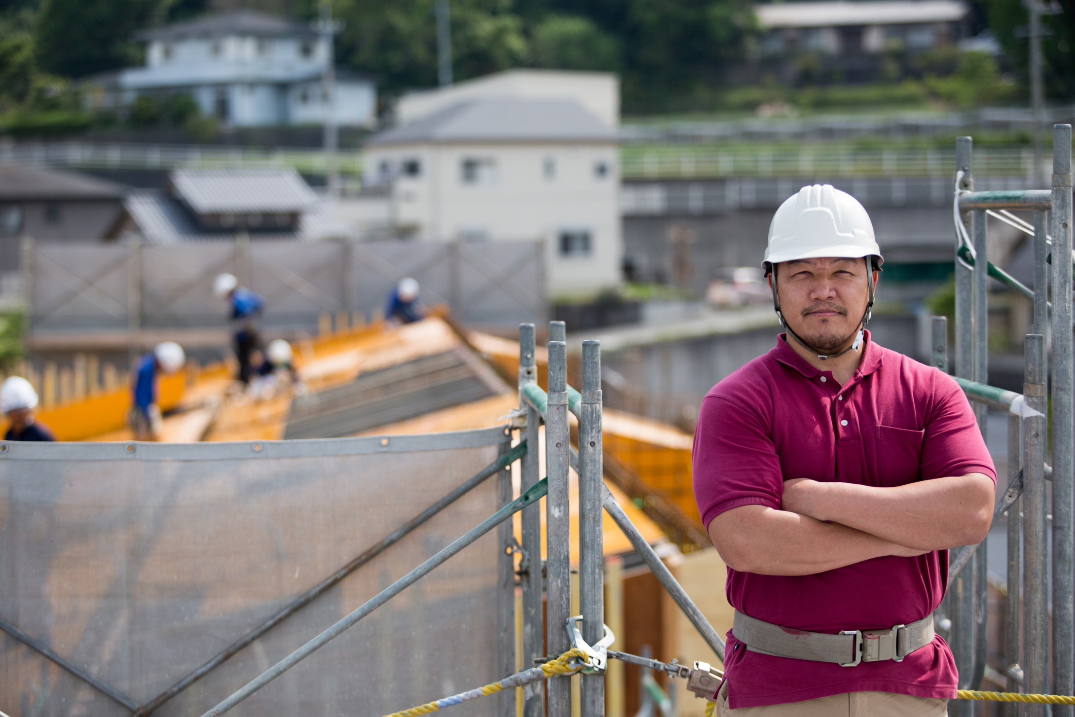 建設作業員が現場で腕を組んでいる写真