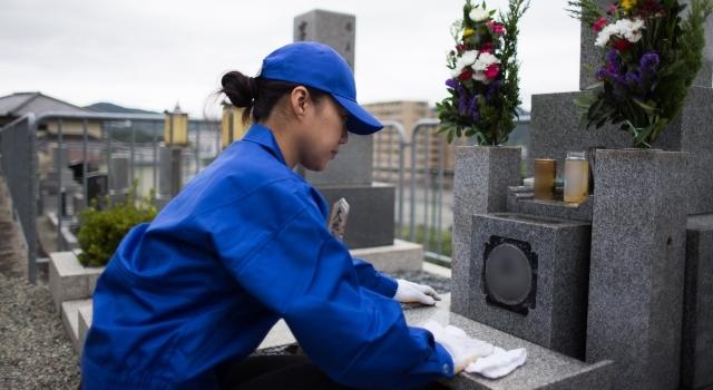 お墓を清掃する作業員