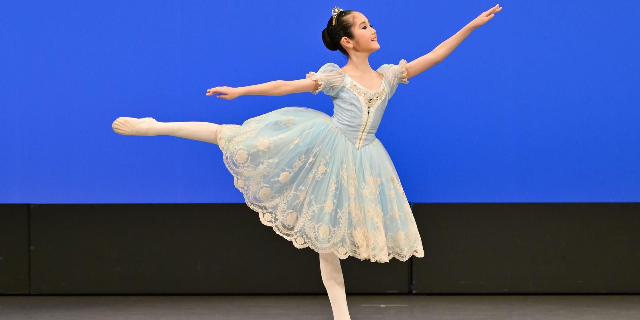 「白鳥の湖」よりパ・ド・トロワ第1ヴァリエーションを踊る小学4年生の生徒の舞台写真