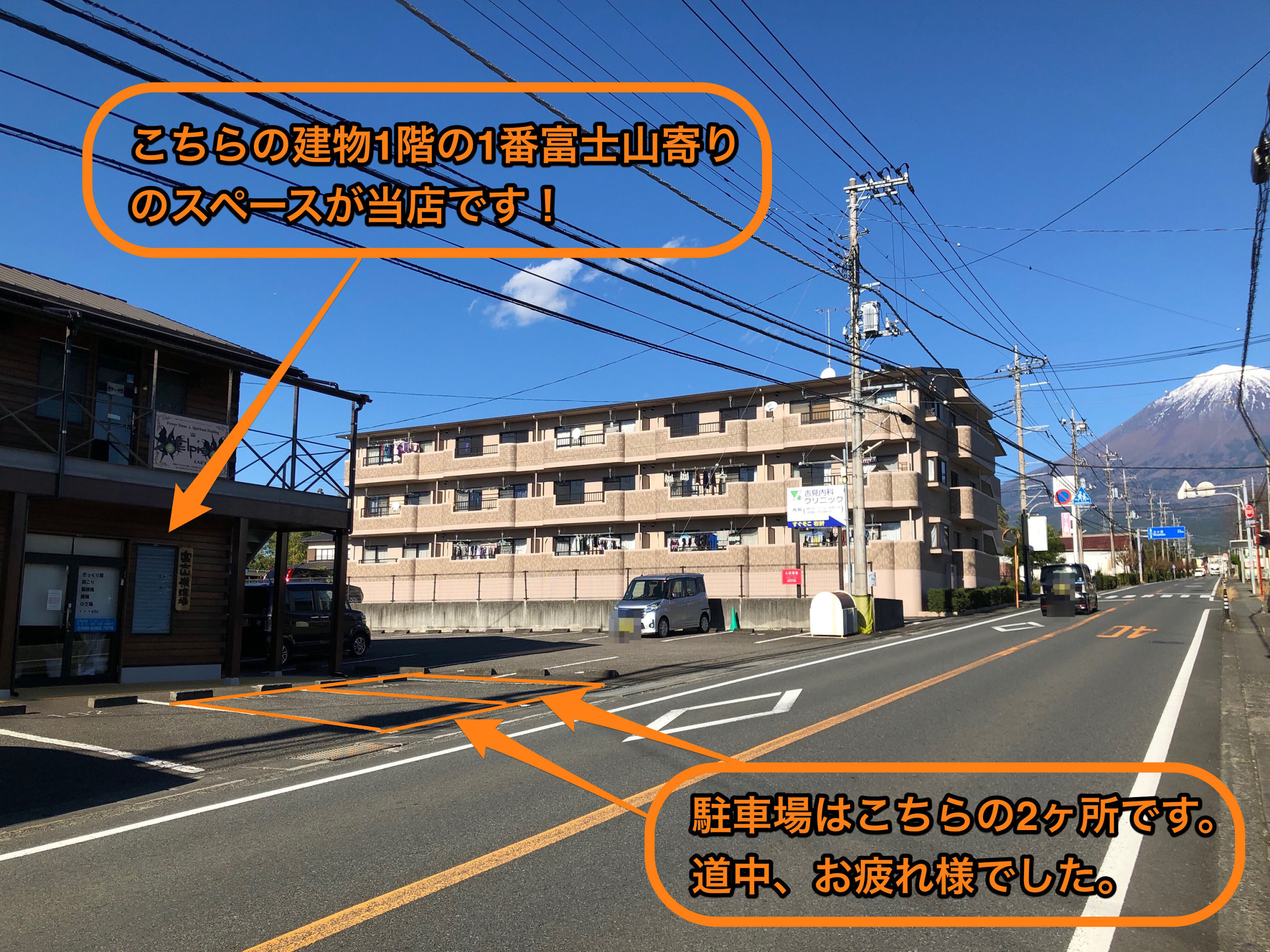 お店の外観と駐車場とその周辺の建物と道路と富士山