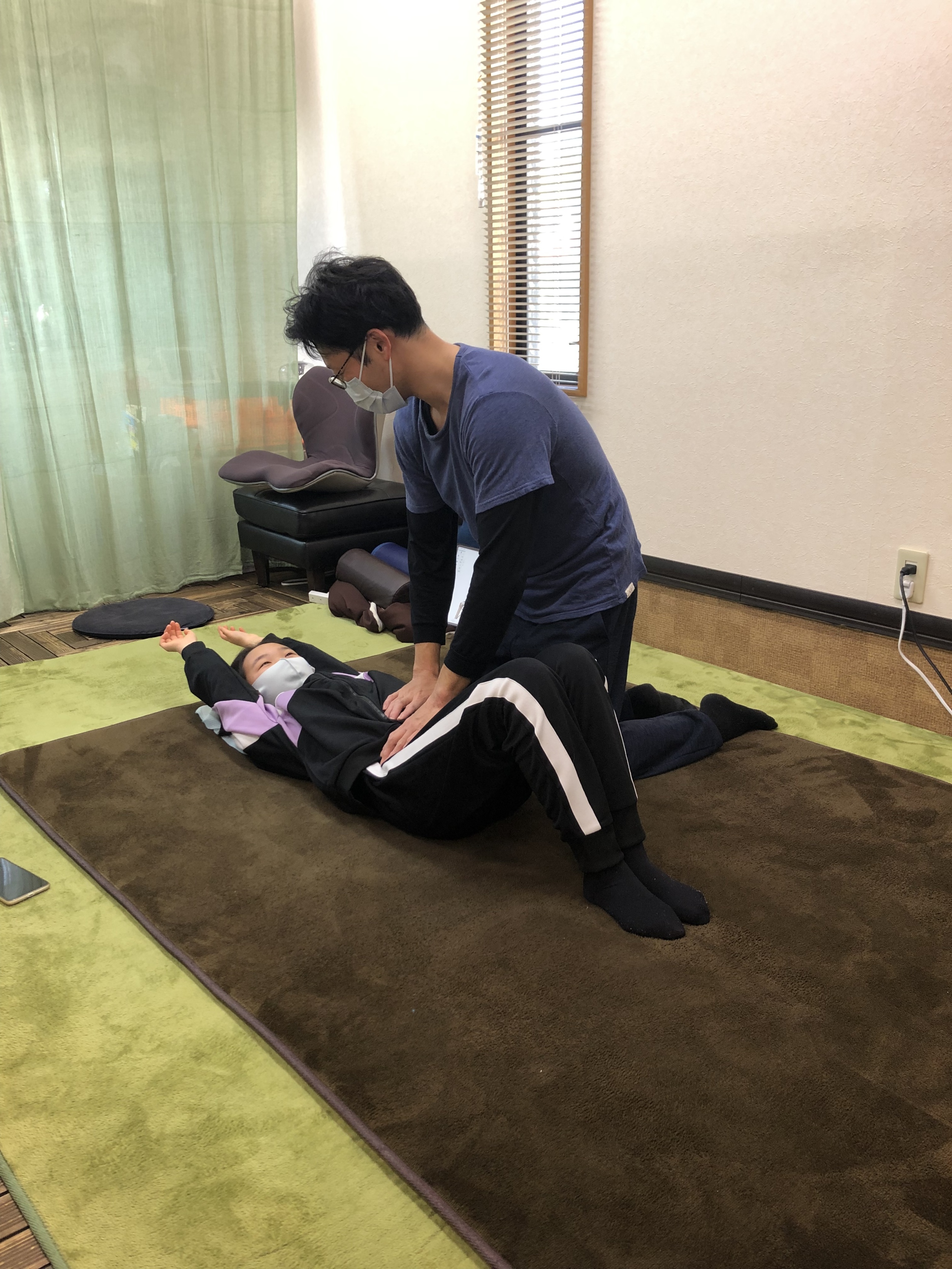 中学生の女子と一緒に両手を挙げている男性