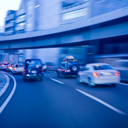 道路を走る数台の乗用車の後ろ姿
