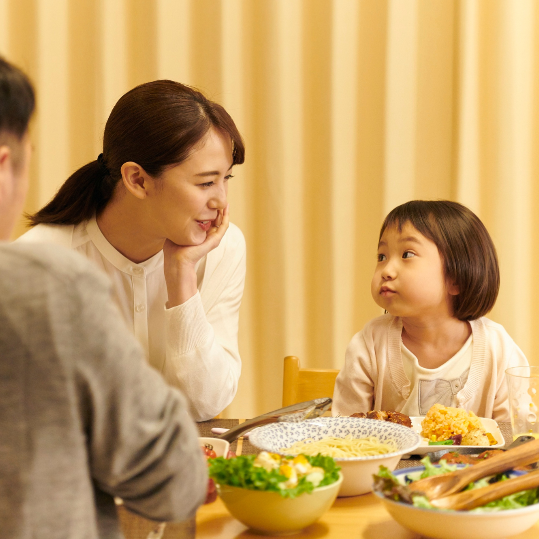 食卓で親が子どもの話を聴いている温かな家庭のシーン