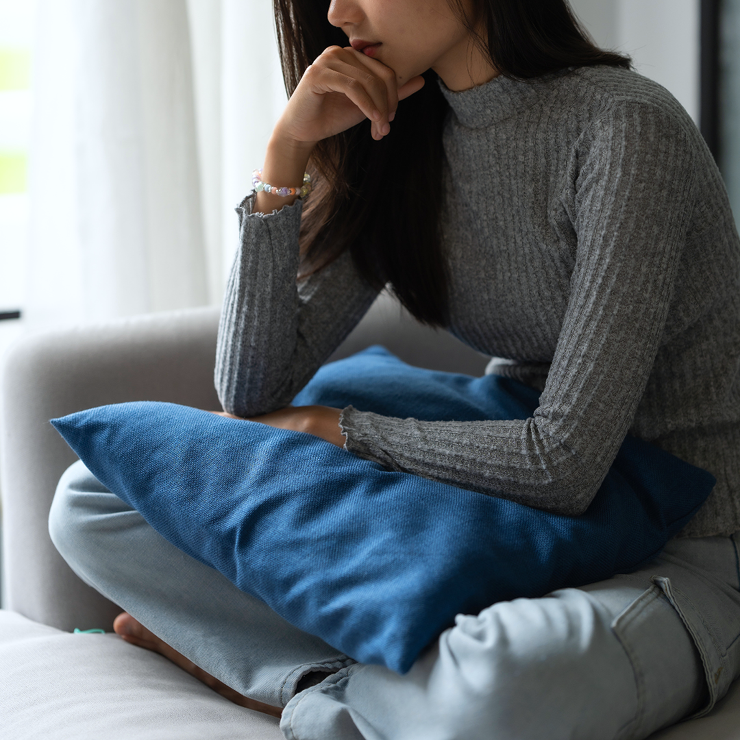 下痢や腹痛、吐き気などの胃腸の不調で、体を丸めて耐えている様子