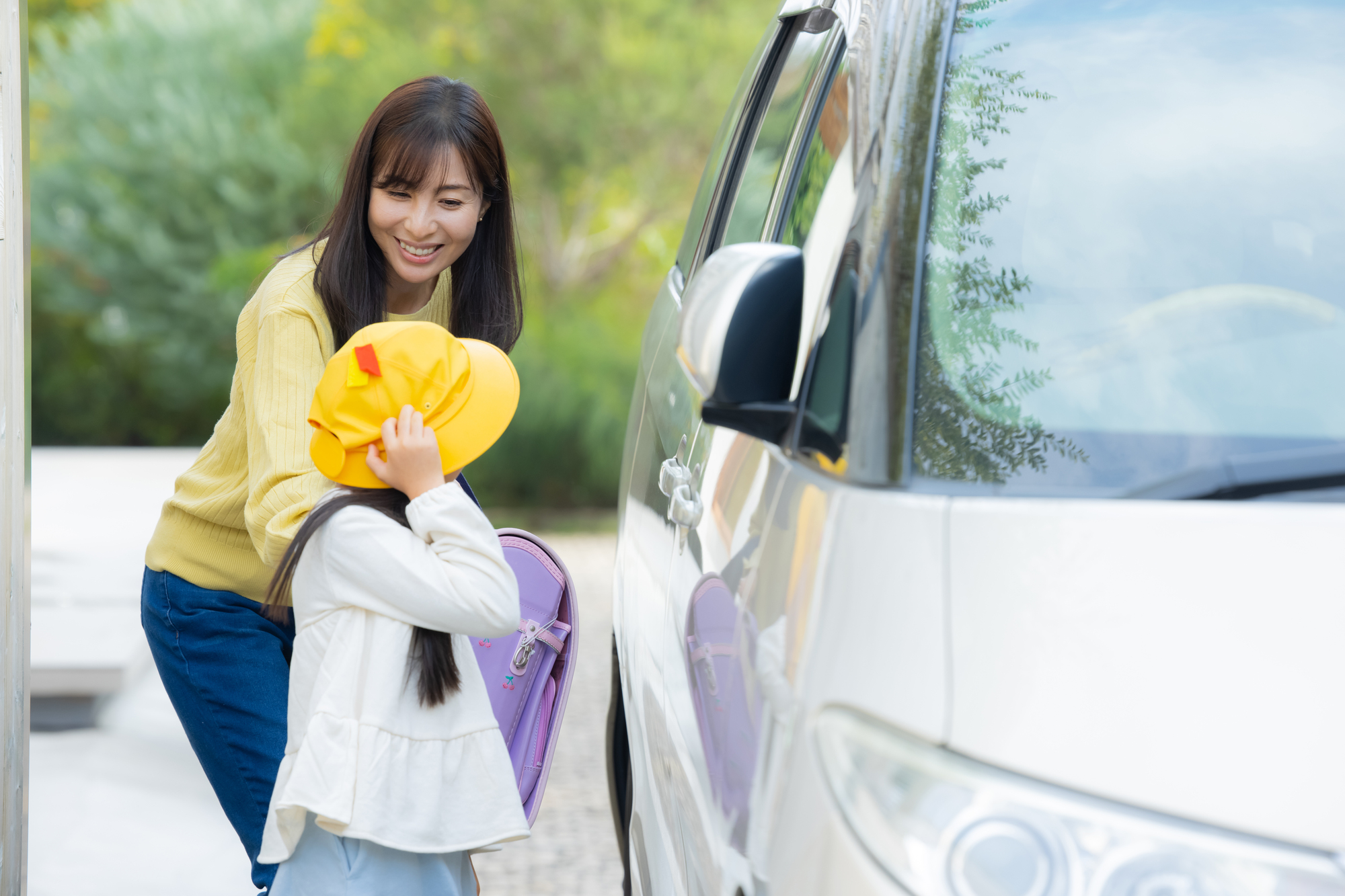 お子様を学校に送迎するお母さん