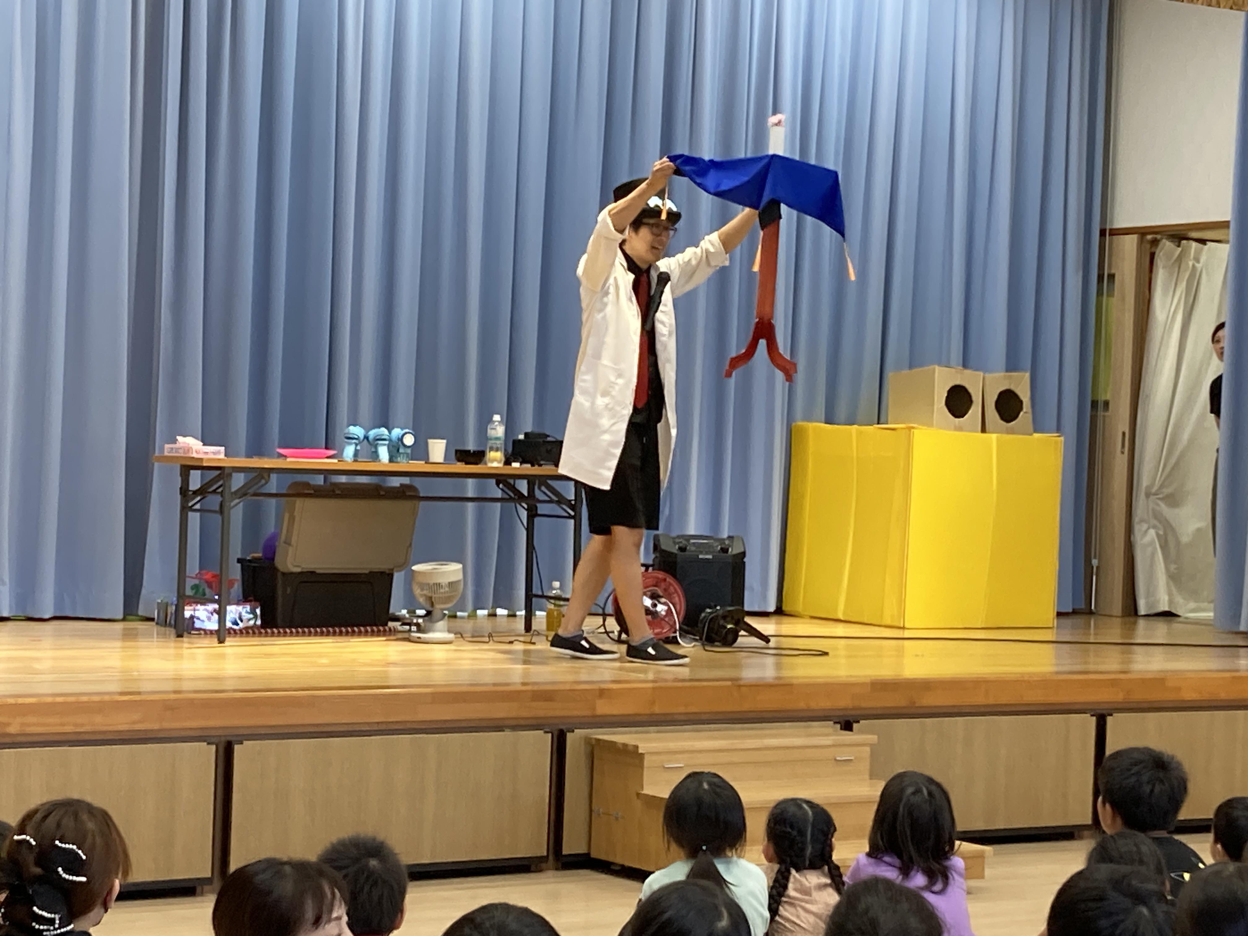 あっけらかんがステージ上でマジックをしてみせる様子