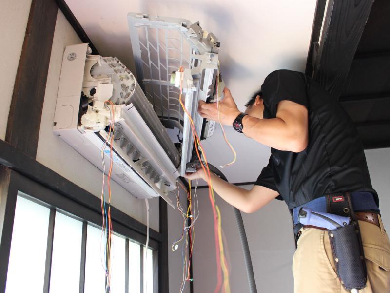 【写真】エアコンクリーニング講習シーン｜実地研修でのお掃除ユニット取り外しの様子