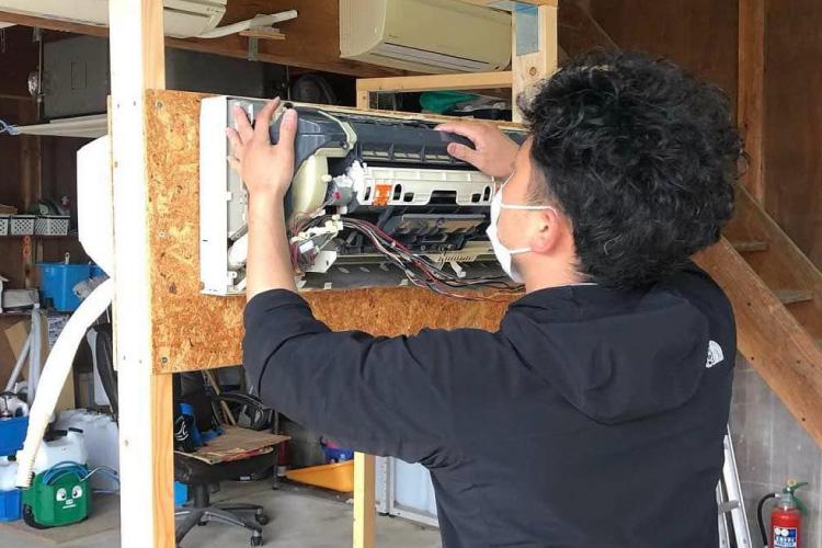 【写真】エアコンクリーニング講習シーン｜お掃除機能付きエアコン分解練習の様子