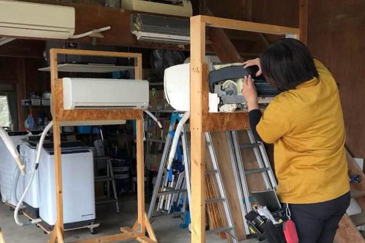 【写真】エアコンクリーニング講習シーン｜お掃除機能ユニット付きエアコン分解練習の様子